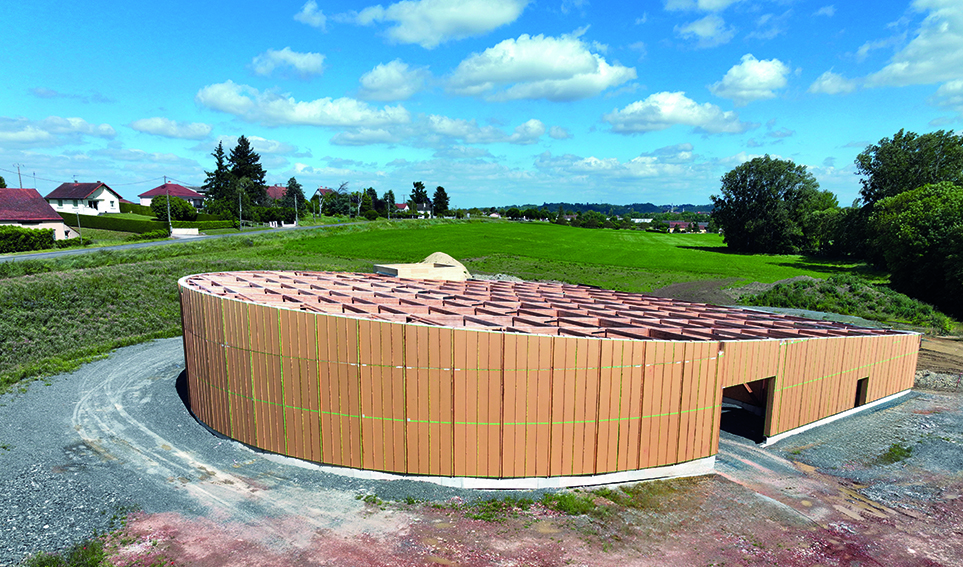 Une façade circulaire en bois-paille pour un chai